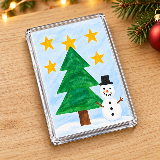 Fridge Magnet showing sample snowman and Christmas tree artwork in a Christmas setting