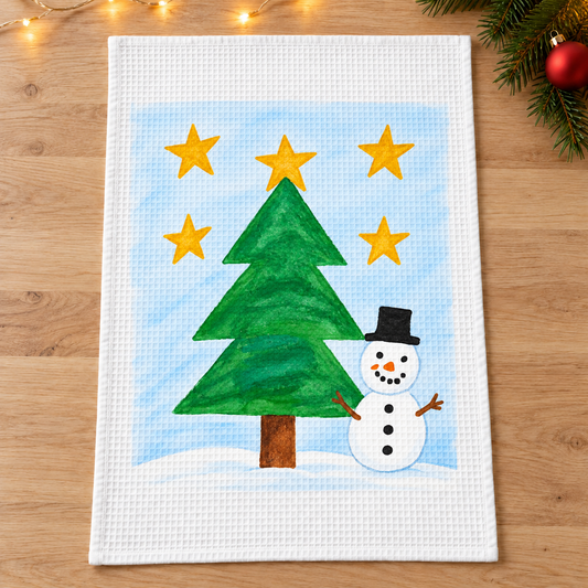 Tea Towel showing sample snowman and Christmas tree artwork in a Christmas setting
